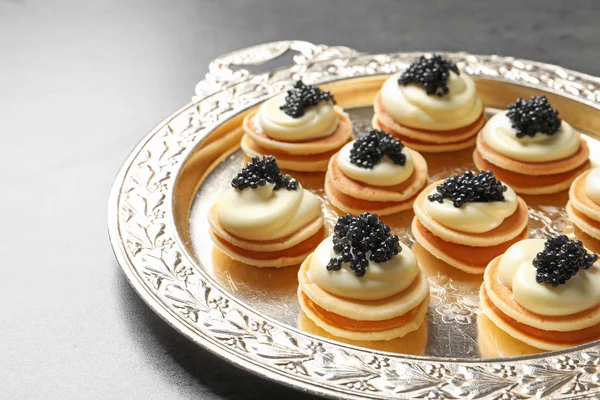 Delikata kanapéer med svart kaviar på metall bricka — Stockfoto