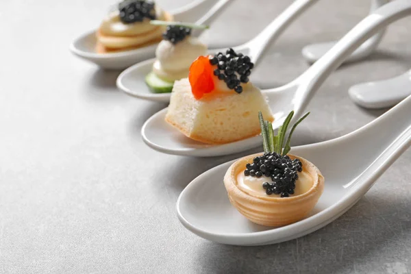 Cucharas de canapés con caviar negro en la mesa —  Fotos de Stock