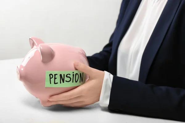 Woman and piggy bank with label "PENSION" at table — Stock Photo, Image