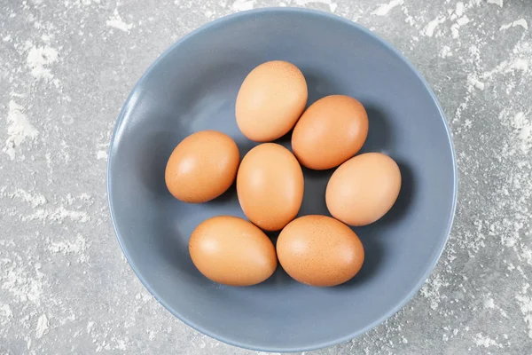 Tallrik med kyckling ägg och mjöl på bordet — Stockfoto