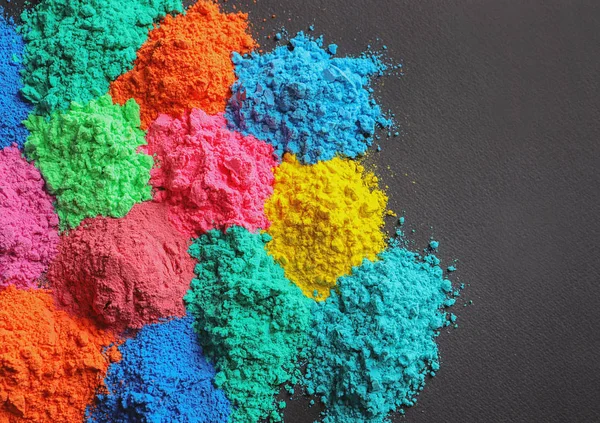 Polvos coloridos para el festival Holi sobre fondo oscuro — Foto de Stock
