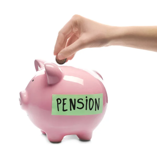 Woman putting coin into piggy bank with label "PENSION" on white background — Stock Photo, Image