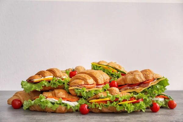 Muitos deliciosos sanduíches de croissant na mesa — Fotografia de Stock