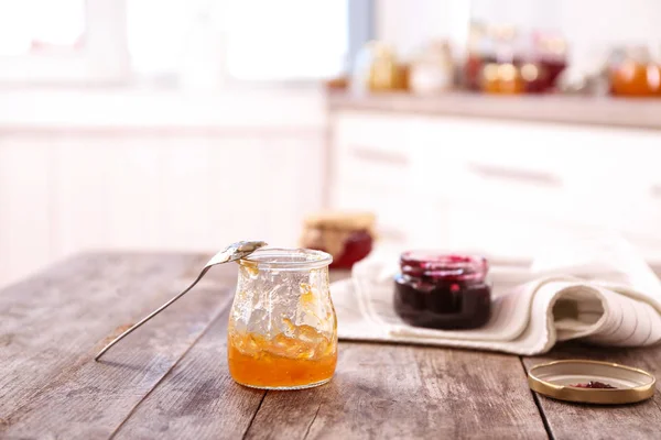 Jar i łyżka z słodkie jam na tabeli — Zdjęcie stockowe