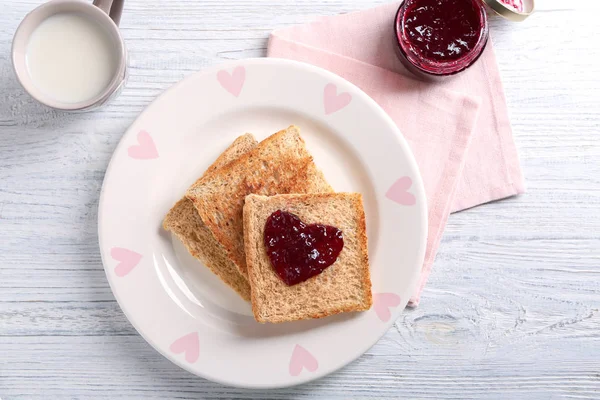 Plate with tasty toasted bread and jam on table — Stock Photo, Image