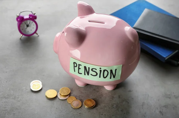 Tirelire avec étiquette "PENSION" et pièces sur la table — Photo