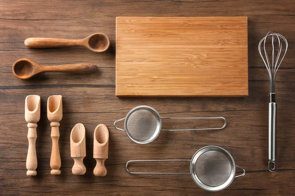 Tabla de cortar y utensilios de cocina sobre fondo de madera. Cursos magistrales de cocina — Foto de Stock