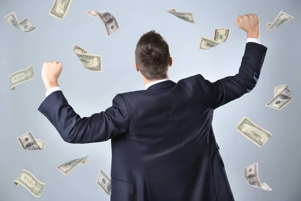 Successful stock broker with flying money on color background — Stock Photo, Image