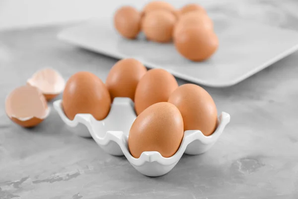 Holder with chicken eggs on table — Stock Photo, Image