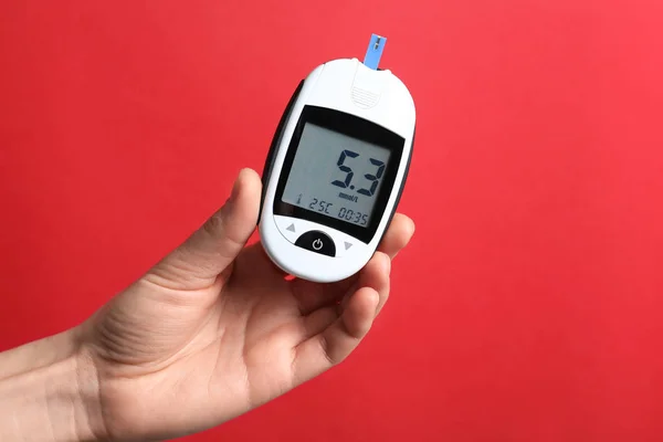 Frau mit digitalem Glukometer auf farbigem Hintergrund. Diabetes-Konzept — Stockfoto