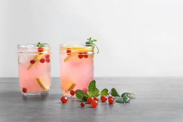 Sabrosa limonada con menta y bayas en frascos en la mesa — Foto de Stock