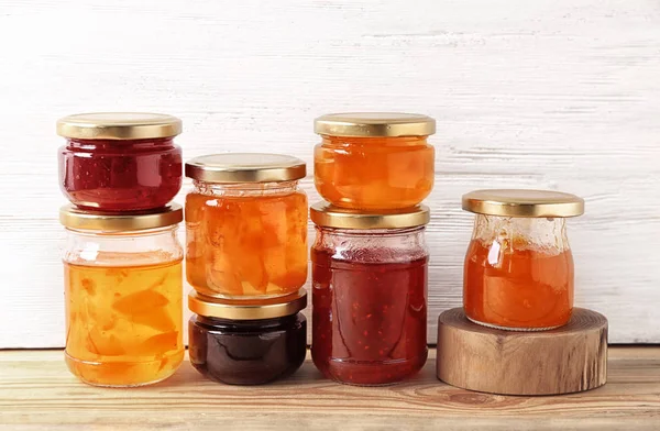 Jars with sweet jams on table — Stock Photo, Image