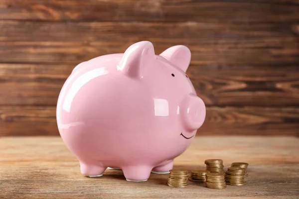 Piggy bank en munten op houten tafel. Pensioenplanning — Stockfoto