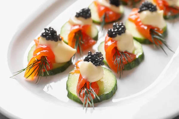 Delikata kanapéer med svart kaviar på tallrik, närbild — Stockfoto