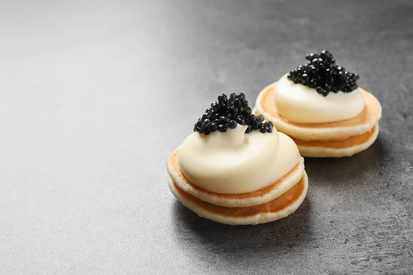 Delikata kanapéer med svart kaviar på grå bakgrund — Stockfoto