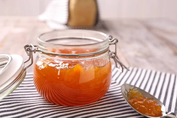 Jar and spoon with sweet jam on table — Stock Photo, Image