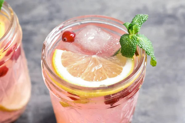 Sabrosa limonada con menta y bayas en frasco en la mesa —  Fotos de Stock