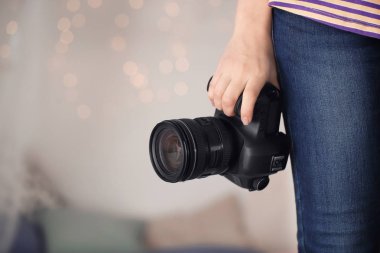 Kamera üzerinde arka plan bulanık tutan kadın fotoğrafçı