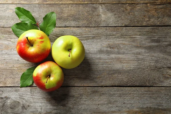 Созревшие сочные яблоки на деревянном столе — стоковое фото