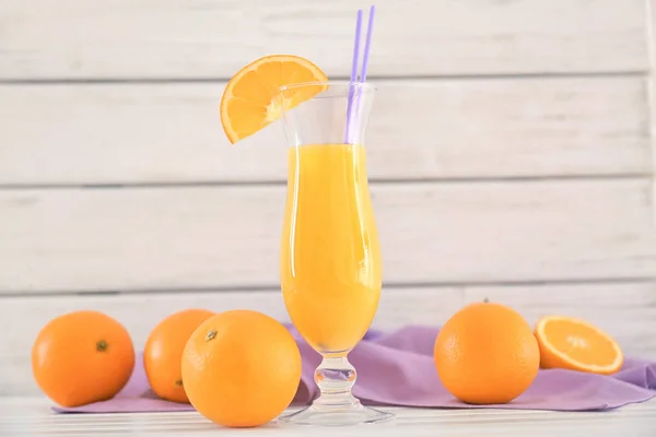 Vaso con zumo de naranja fresco y fruta en la mesa — Foto de Stock