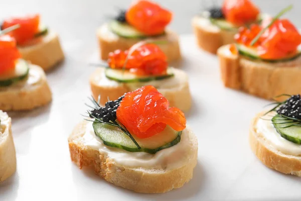 Delicious canapes with black and red caviar on light background — Stock Photo, Image