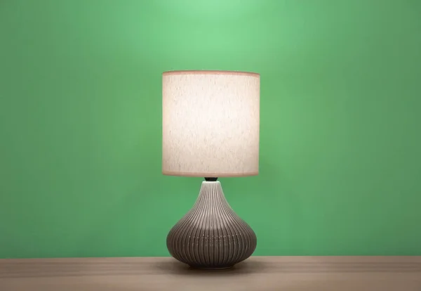 Stijlvolle lamp op tafel tegen kleur muur — Stockfoto