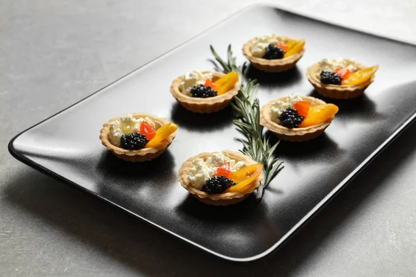 Deliziose tartine con caviale nero sul piatto — Foto Stock