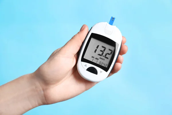 デジタル glucometer 色の背景上に保持している女性。糖尿病の概念 — ストック写真