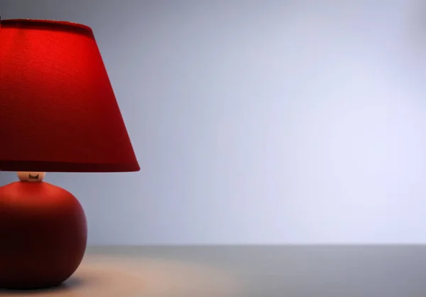 Elegante lámpara en la mesa contra el fondo de color — Foto de Stock