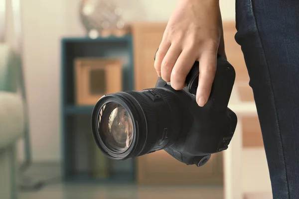 Fotógrafo feminino segurando câmera dentro de casa — Fotografia de Stock