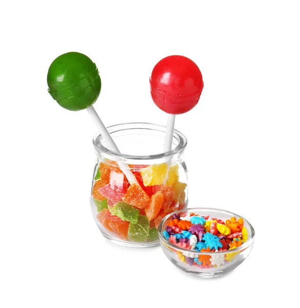 Artículos de vidrio con diferentes caramelos de colores sobre fondo blanco — Foto de Stock