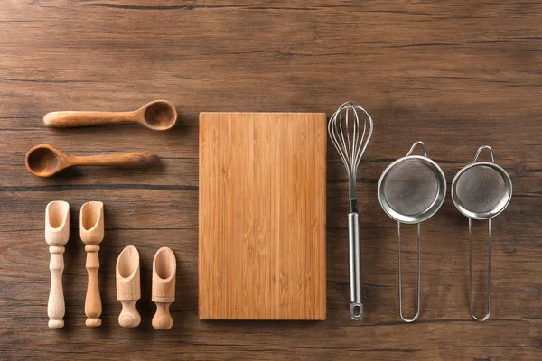Tabla de cortar y utensilios de cocina sobre fondo de madera. Cursos magistrales de cocina — Foto de Stock