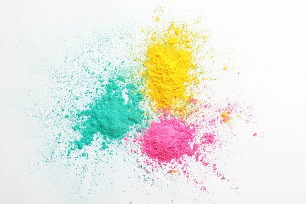 Polvos coloridos para el festival Holi sobre fondo blanco — Foto de Stock