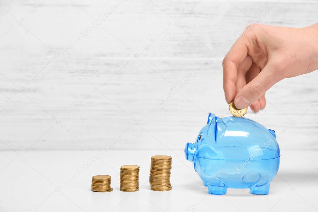 Woman putting coin into piggy bank. Pension planning