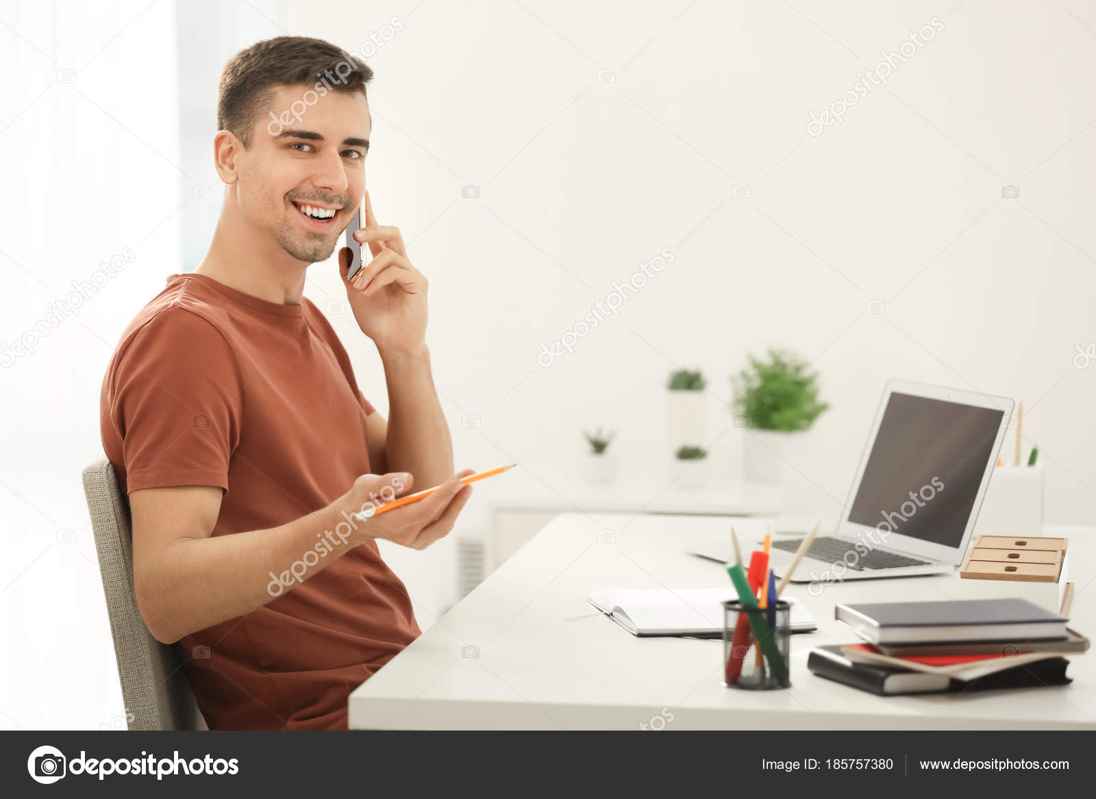 Junger Mann am Telefon sprechen während der Arbeit im Büro ...