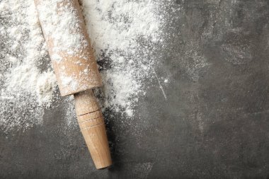 Dağınık un ve oklava gri masada