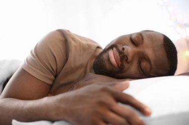 Adam yatakta uyuyor.