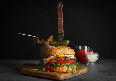 Ahşap tahta karşı koyu arka plan üzerinde lezzetli burger