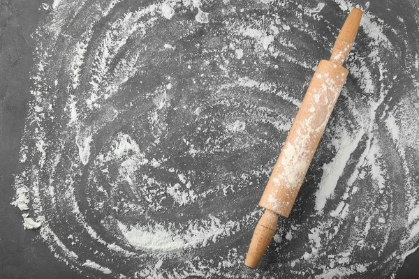 Farinha dispersa e rolo em mesa cinza — Fotografia de Stock