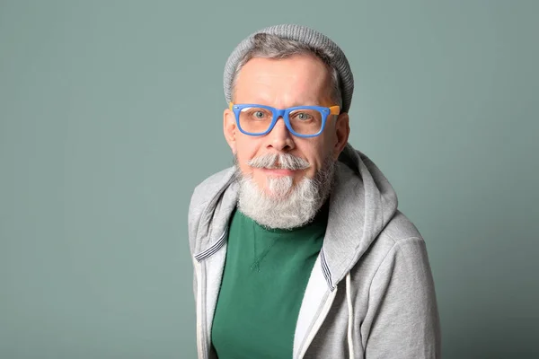 Gelukkig senior man in hipster outfit op grijze achtergrond — Stockfoto