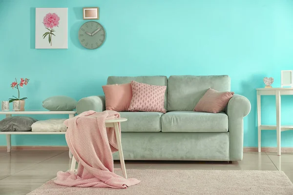Elegante tavolo con coperta vicino divano menta in soggiorno — Foto Stock
