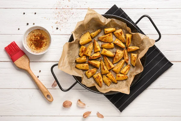 Dish with delicious oven baked potatoes on table — Stock Photo, Image