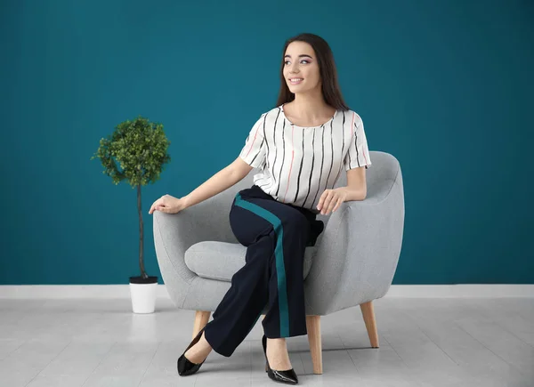 Young woman sitting in armchair — Stock Photo, Image