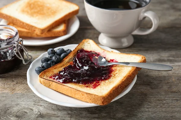 Delizioso brindisi con marmellata dolce sul piatto — Foto Stock