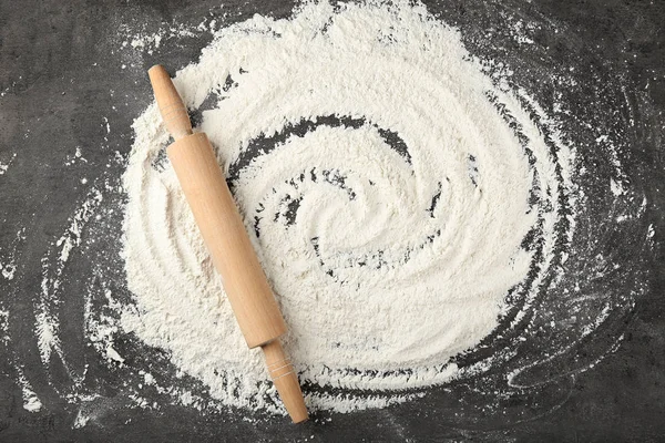 散乱の小麦粉と灰色のテーブルに麺棒 — ストック写真
