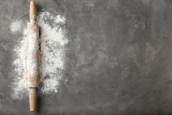 Farinha dispersa e rolo em mesa cinza — Fotografia de Stock