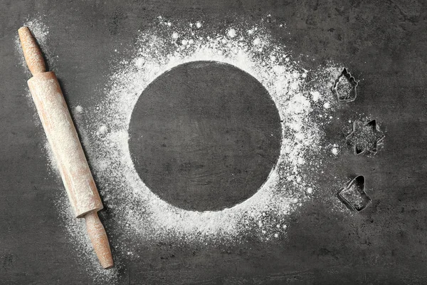 Round frame made of flour, rolling pin and cookie cutters on grey background, top view — Stock Photo, Image