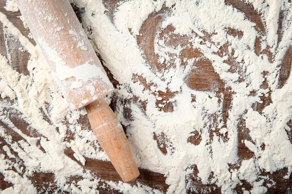 Farina sparsa e mattarello sul tavolo di legno — Foto Stock