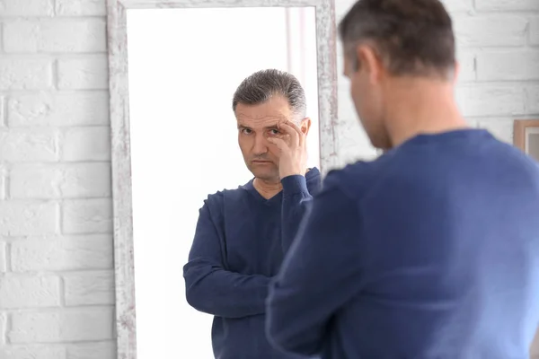 Tankeväckande mogen man står nära spegeln hemma — Stockfoto