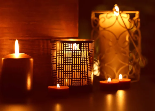 Beautiful holders with burning candles in darkness — Stock Photo, Image